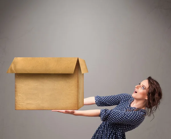 Mujer joven sosteniendo una caja de cartón vacía —  Fotos de Stock
