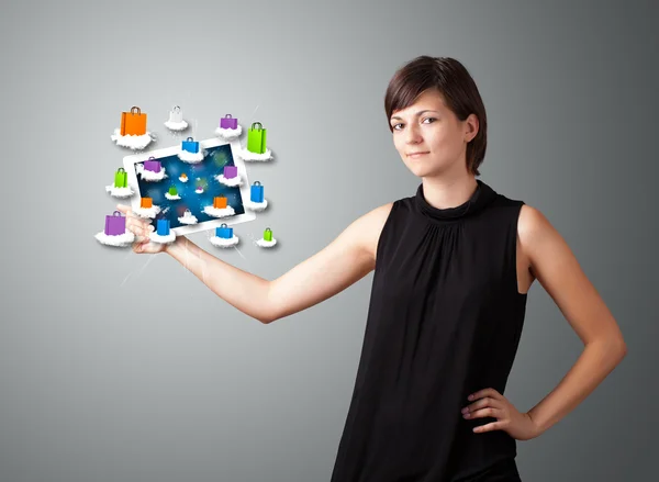 Vrouw met moderne tablet met kleurrijke boodschappentassen op wolk — Stockfoto