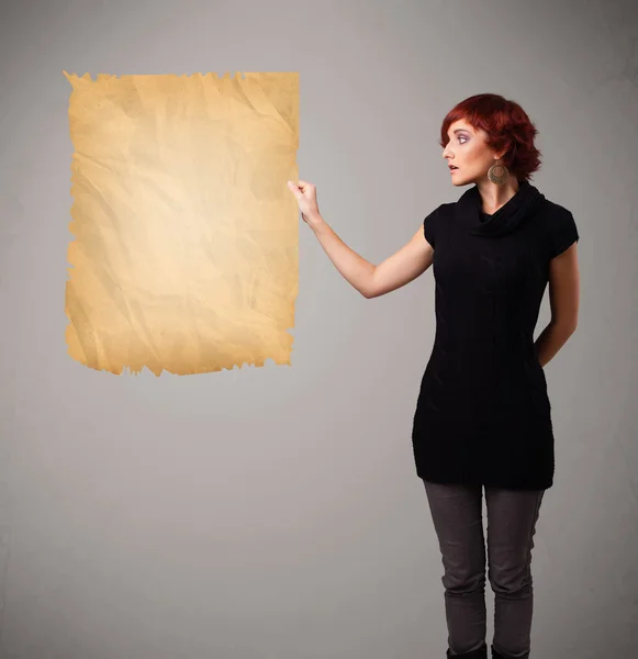 Młoda dziewczyna prezentuje stary papierowy przestrzeń kopia — Zdjęcie stockowe