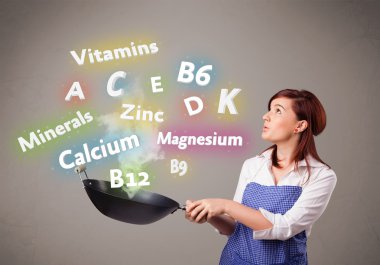 Genç bir kadın vitamin ve mineral pişiriyor.