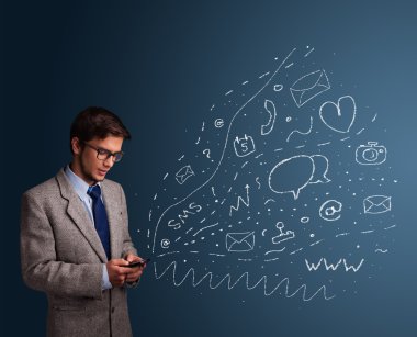 Çeşitli modern teknoloji simgeleriyle akıllı telefonda yazan çocuk.