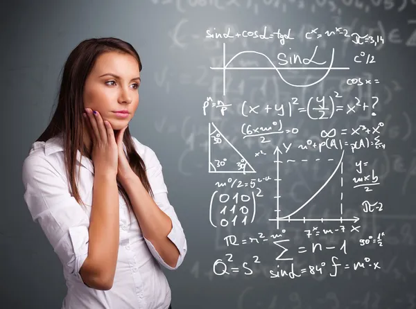 Красивая школьница думает о сложных математических знаках — стоковое фото