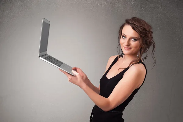 Молода жінка тримає сучасний ноутбук — стокове фото