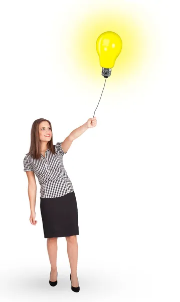 Mulher feliz segurando um balão lâmpada — Fotografia de Stock