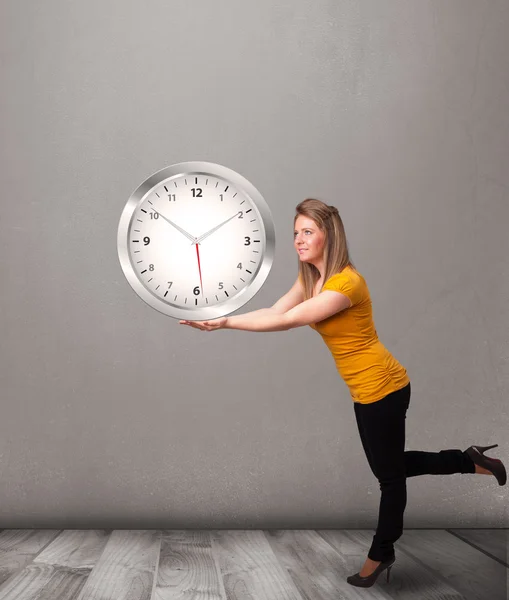 Attraktiv dam som håller en enorm klocka — Stockfoto