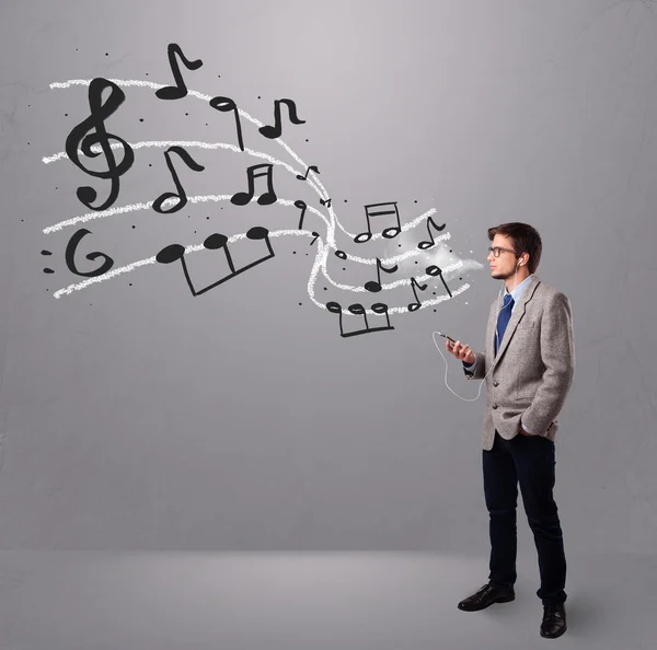 Menino bonito cantando e ouvindo música com notas musicais — Fotografia de Stock