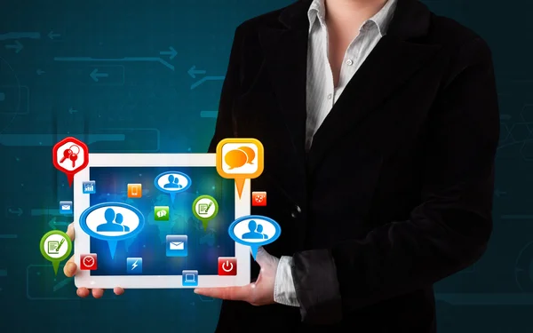 Ragazza che presenta un tablet con icone sociali colorate e segni — Foto Stock