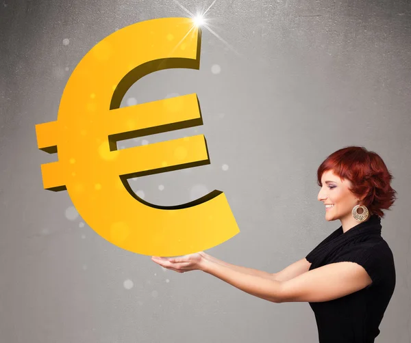Beautiful girl holding a big 3d gold euro sign — Stock Photo, Image