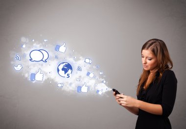 Sosyal medya simgeleriyle telefon tutan güzel bir genç kız.
