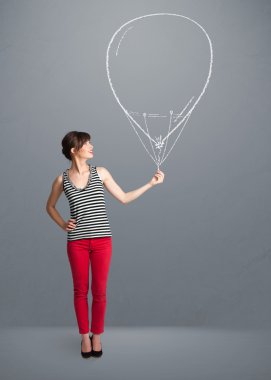 Güzel bir kadın balon çiziyor.