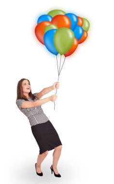 Genç bir kadın elinde renkli balonlar tutuyor.