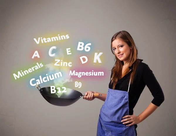 Young woman cooking vitamins and minerals — Stock Photo, Image