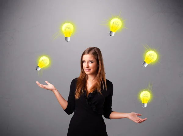 Jeune femme debout et jonglant avec des ampoules — Photo