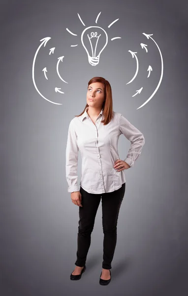 Pretty lady thinking with arrows and light bulb overhead — Stock Photo, Image