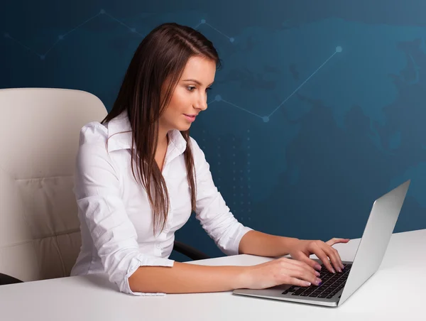 Jonge vrouw zit aan het bureau en typt op laptop — Stockfoto