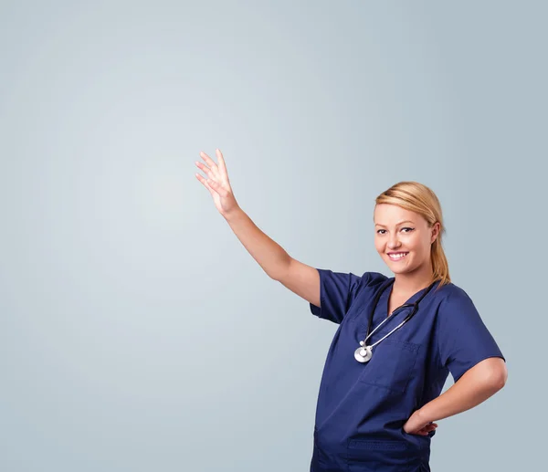 Jonge vrouwelijke arts gebaren met kopieerruimte — Stockfoto