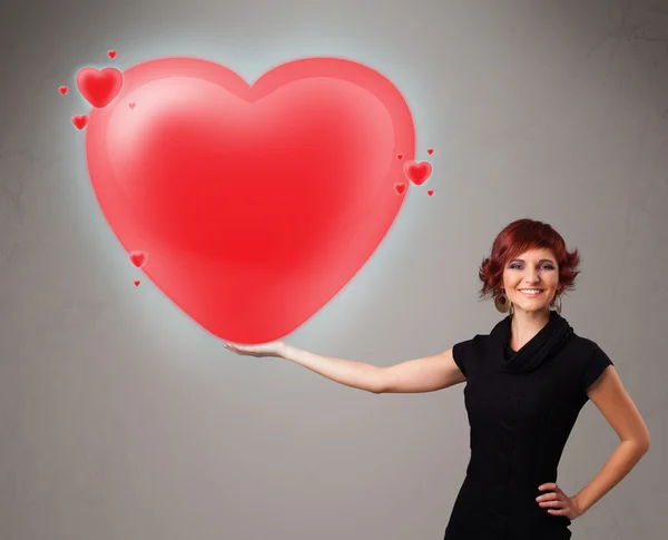 Young lady holding lovely 3d red heart — Stock Photo, Image