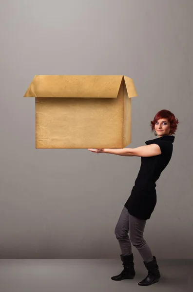 Jovem segurando uma caixa de papelão vazia — Fotografia de Stock