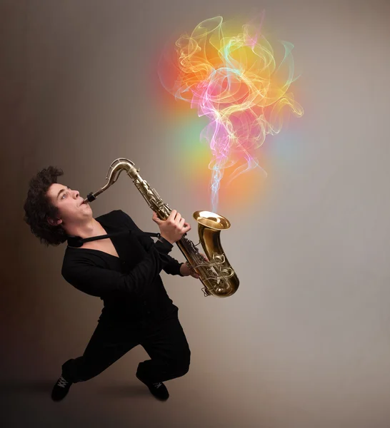 Atraktivní hudebník hrající na saxofon s barevnými abstrakt — Stock fotografie