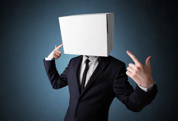 Businessman gesturing with a cardboard box on his head — Stock Photo, Image