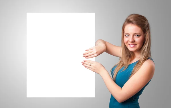 Young woman presenting white paper copy space — Stock Photo, Image