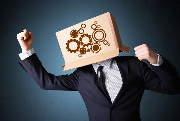 Businessman gesturing with a cardboard box on his head with spur — Stock Photo, Image