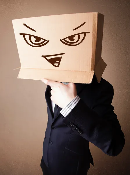 Бізнесмен жестикулює з картонною коробкою на голові зі злом — стокове фото