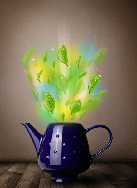 Teekanne mit Blättern und bunten abstrakten Lichtern — Stockfoto
