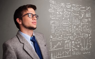 Borsa grafiklerine ve sembollerine bakan çekici bir adam.