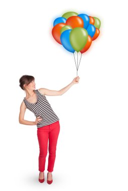 Genç bir kadın elinde renkli balonlar tutuyor.