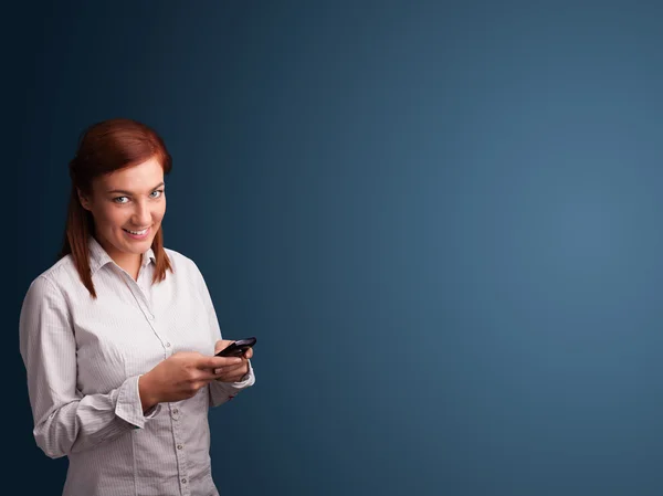 Junge Frau steht und tippt auf ihrem Handy mit Kopierplatz — Stockfoto