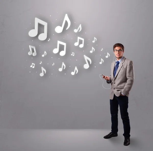 Attractive young man singing and listening to music with musical — Stock Photo, Image