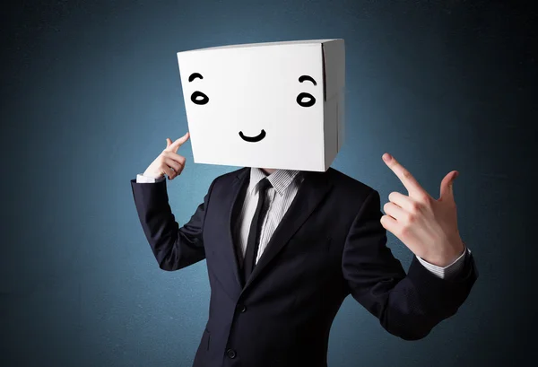 Businessman gesturing with a cardboard box on his head with smil — Stock Photo, Image