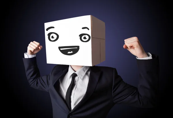 Işadamı SMIL ile kafasına bir karton kutu ile el hareketi — Stok fotoğraf