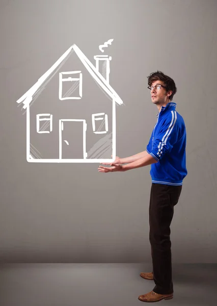 Young boy holding a huge drawn house — Stock Photo, Image
