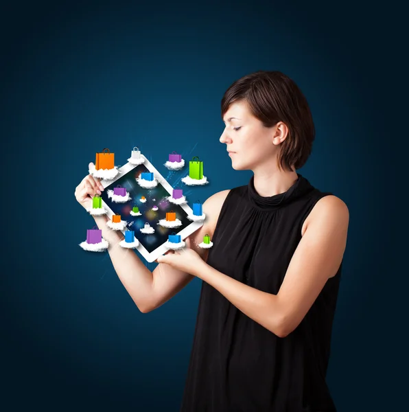 Žena drží moderní tablet s barevnými nákupní tašky na mrak — Stock fotografie