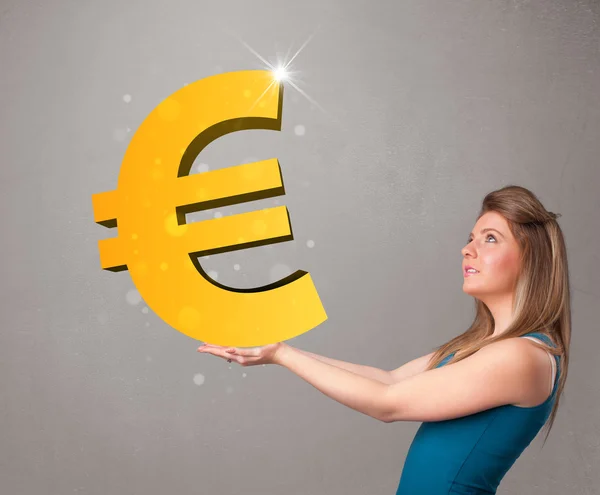 Beautiful girl holding a big 3d gold euro sign — Stock Photo, Image