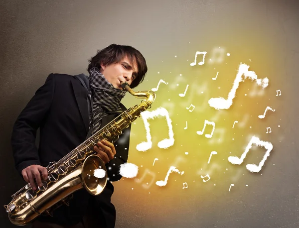 Beau musicien jouant sur saxophone avec des notes musicales — Photo