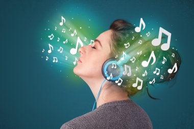 Kulaklıklı genç bir kadın müzik dinliyor.