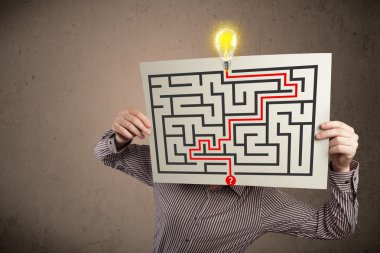 bir labirent ile bir kağıt üzerinde h tutan işadamı