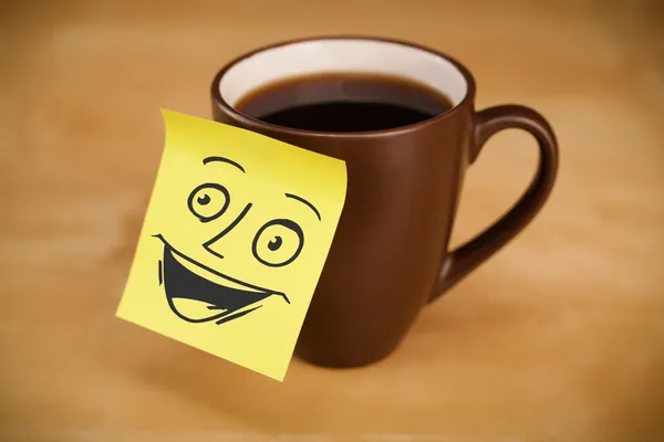 Nota post-it con la cara sonriente pegada en una taza — Foto de Stock