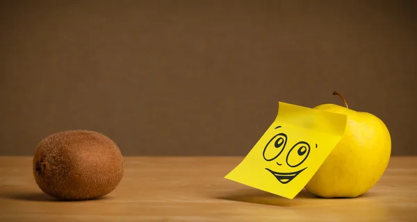 Apple with post-it note looking at kiwi — Stock Photo, Image