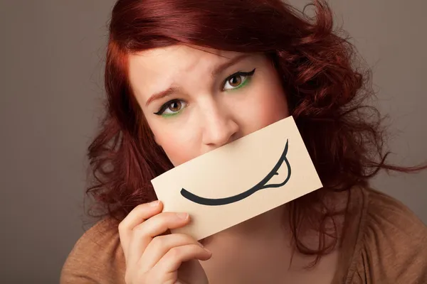 Bella ragazza in possesso di carta bianca con disegno sorriso — Foto Stock