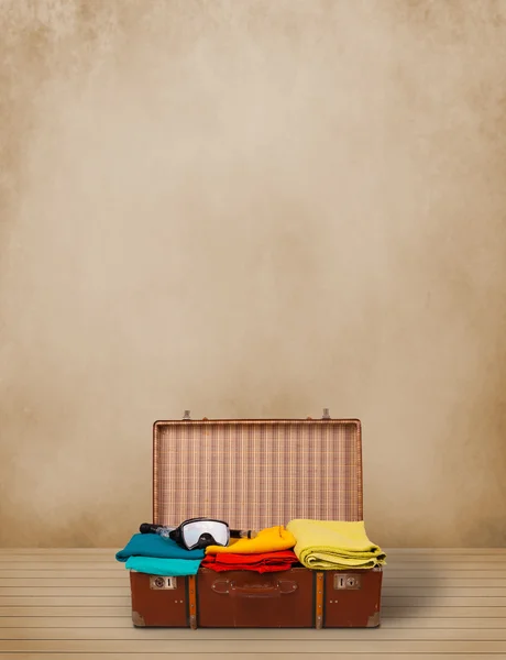 Retro tourist luggage with colorful clothes and copyspace — Stock Photo, Image