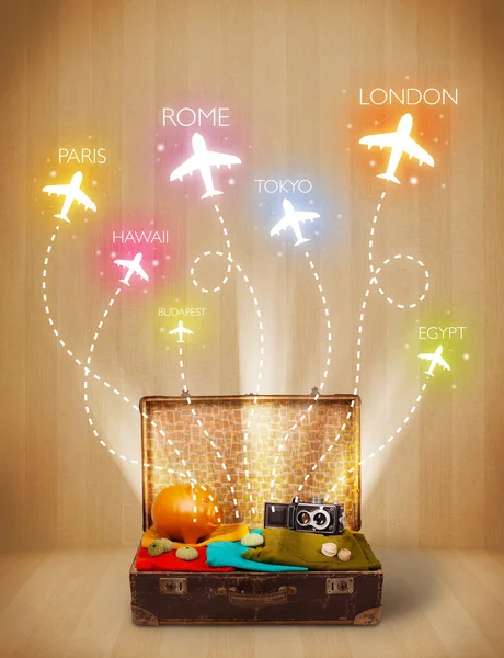 Travel bag with clothes and colorful planes flying out — Stock Photo, Image