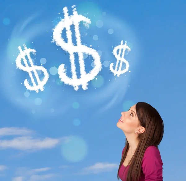 Young girl pointing at dollar sign clouds on blue sky — Stock Photo, Image