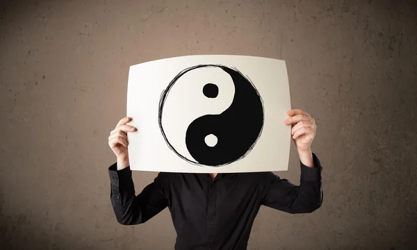 Affärsman hålla ett papper med en yin och yang på det framför Hej — Stockfoto