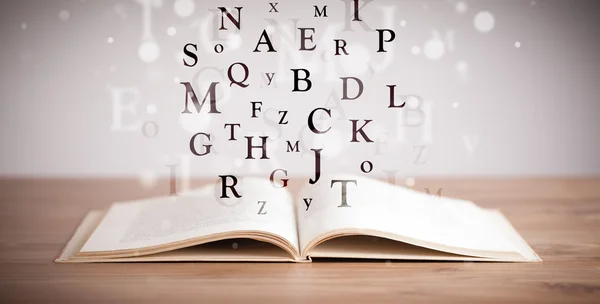 Livre ouvert avec lettres volantes — Photo