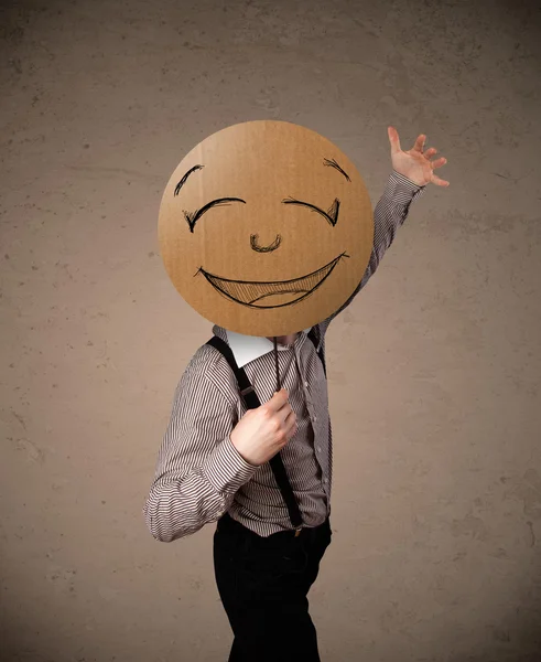 Homme d'affaires tenant un panneau de visage souriant — Photo