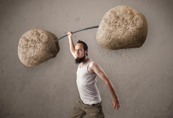 Skinny guy lifting large rock stone weights — Stock Photo, Image